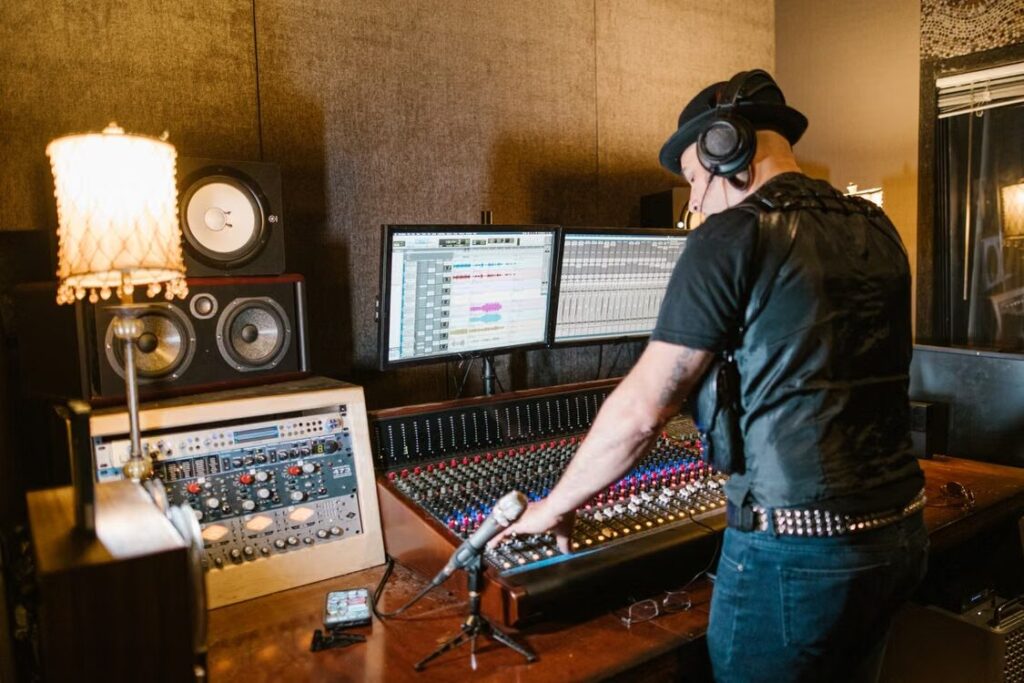 Audio engineer directing and monitoring a voice recording session.